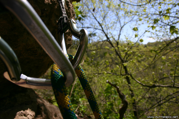 Two quickdraws anchor a rope atop a route named 